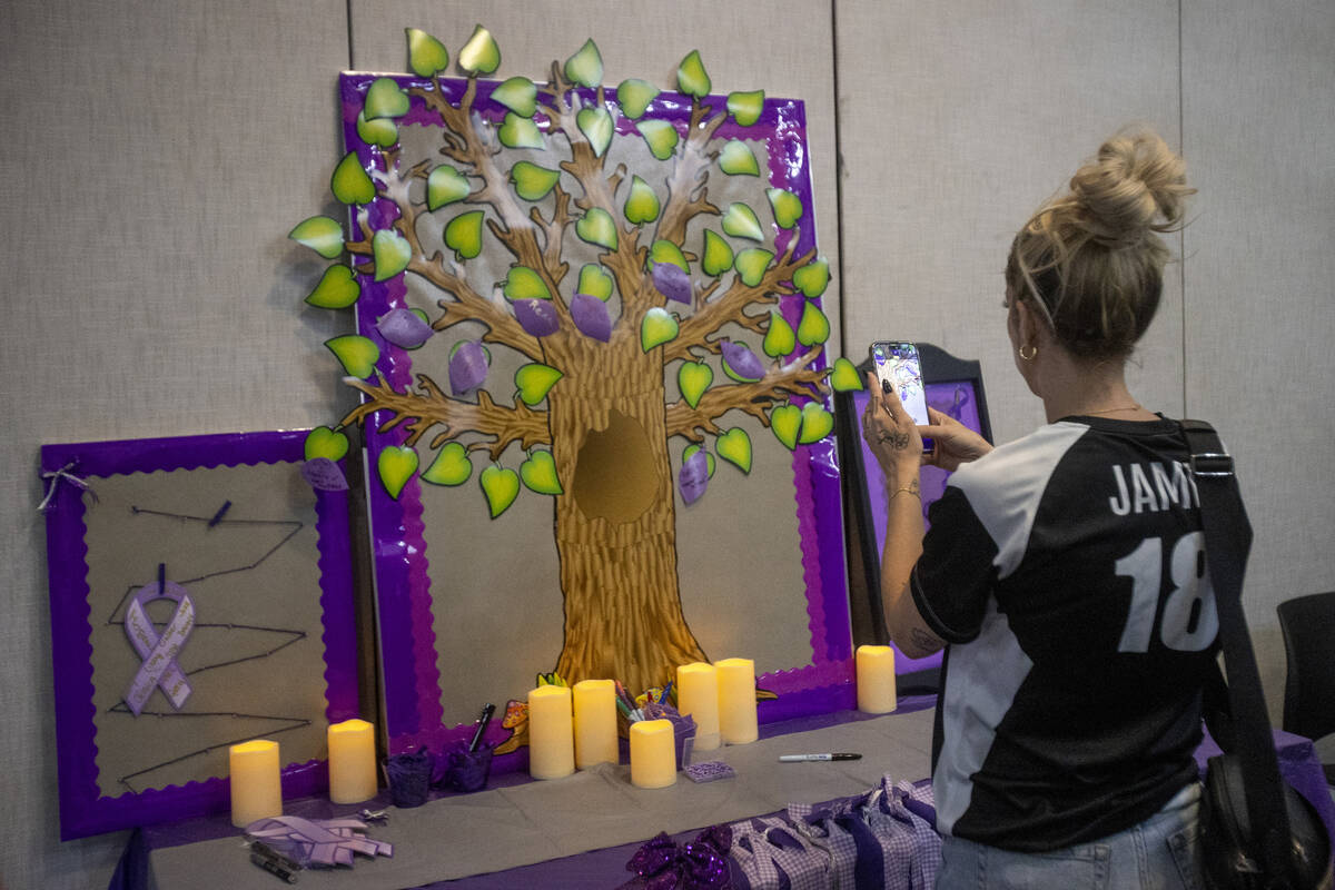 Jamie Hatfield takes a photograph of a leaf they recently pinned to a remembrance tree for a fr ...