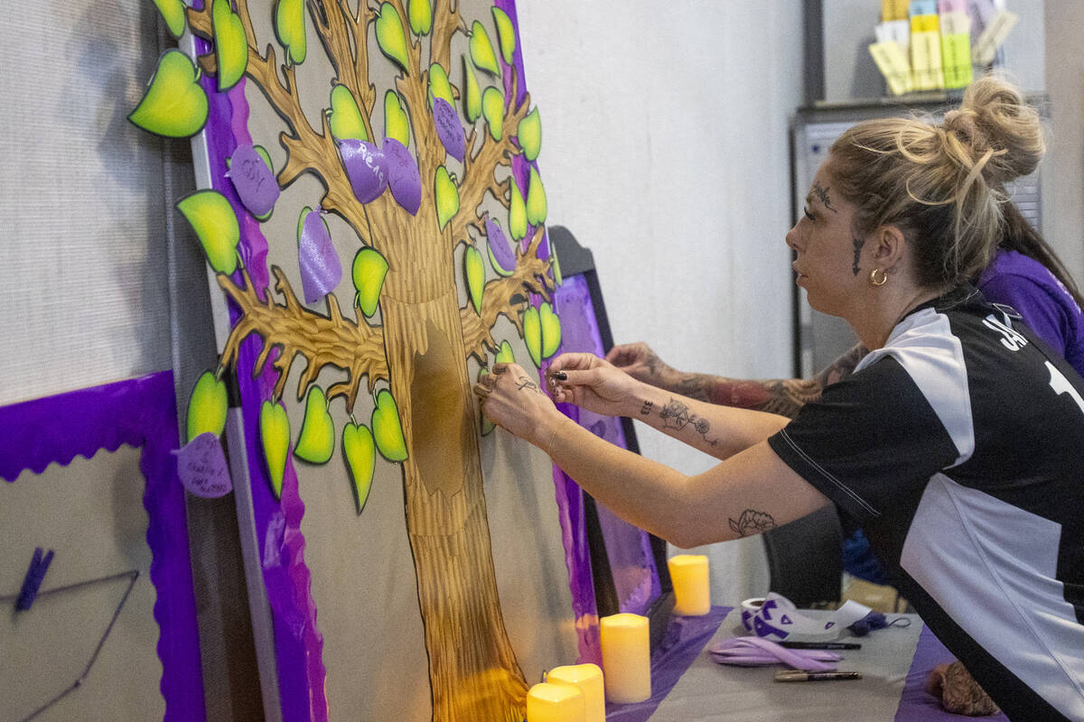 Jamie Hatfield pins a leaf to a remembrance tree for a friend who recently passed away during t ...