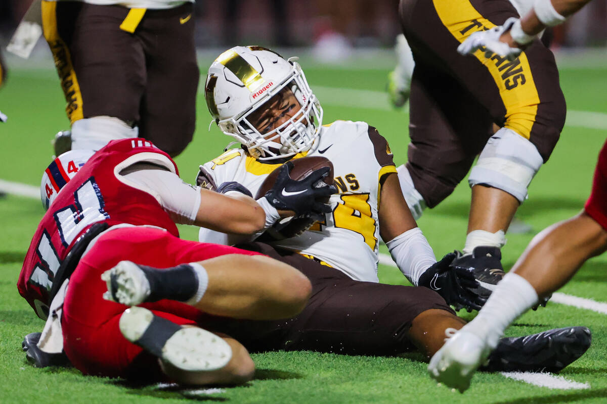 Mililani linebacker Prince Tominiko, right, is tackled by Liberty tight end Nicholas Battisti d ...