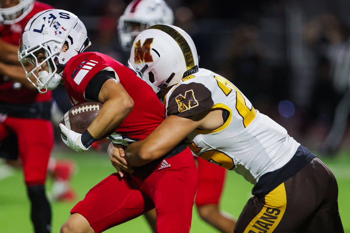 Liberty wide receiver Kellen Iwamuro (8) struggles to move the ball forward as Mililani linebac ...