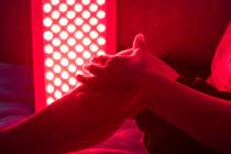 Closeup of sore leg of a person treating with the red light therapy panel (Getty Images)