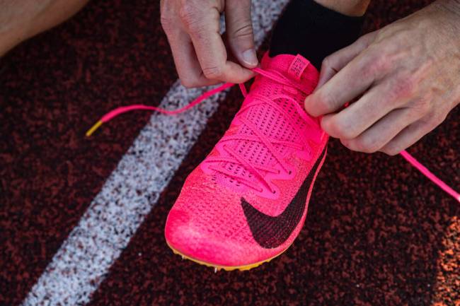 Troy Adashun, a local fitness influencer, ties his shoes before sprinting for a video about tra ...