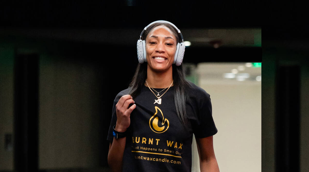 Aces star A'ja Wilson poses wearing a shirt that reps her and her mother's candle line, Burnt W ...