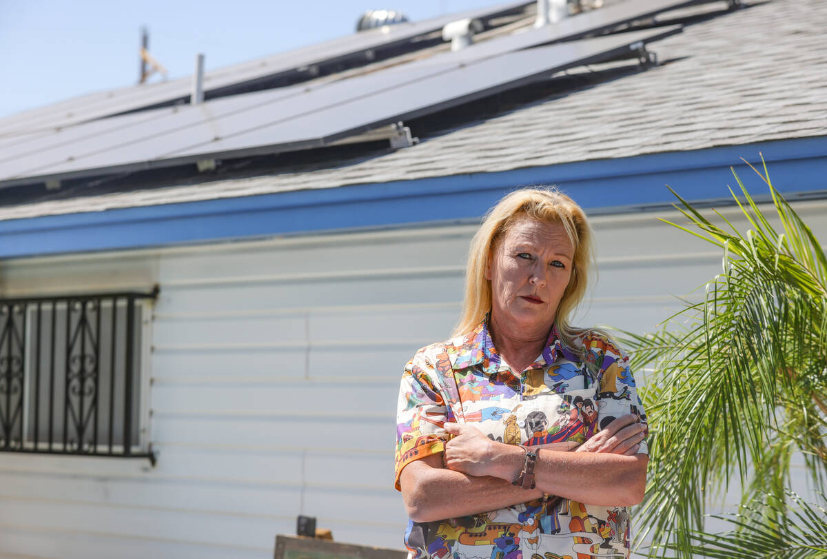 Charlyne Cutler, a victim of a solar panel scam, poses for a portrait near the solar panels at ...