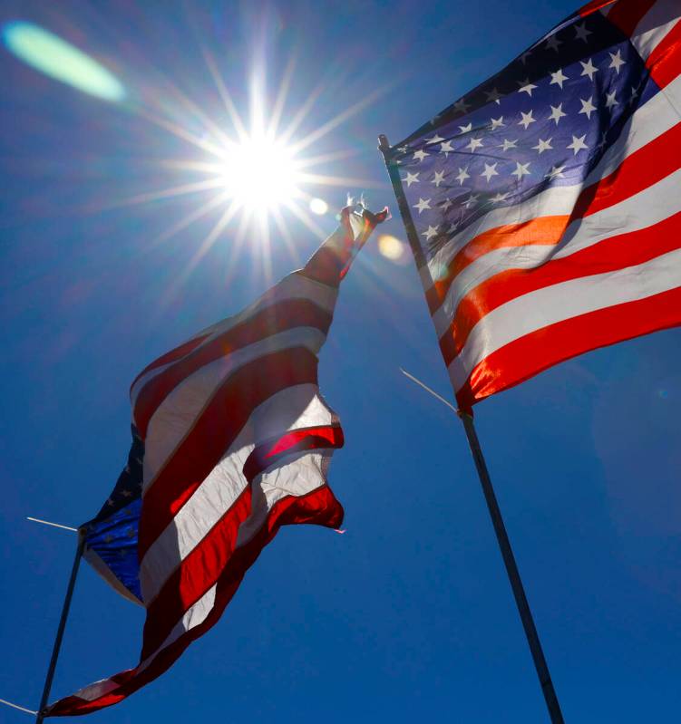 The afternoon sun light rays pierce through American flags, on Monday, July 1, 2024, in Las Veg ...