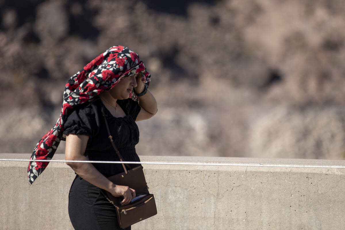 Tourists shade themselves at the Hoover Dam Friday, July 5, 2024, in Boulder City. (Daniel Jaco ...