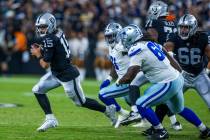 Raiders quarterback Gardner Minshew (15) looks for yardage after flushed from the pocked by Dal ...