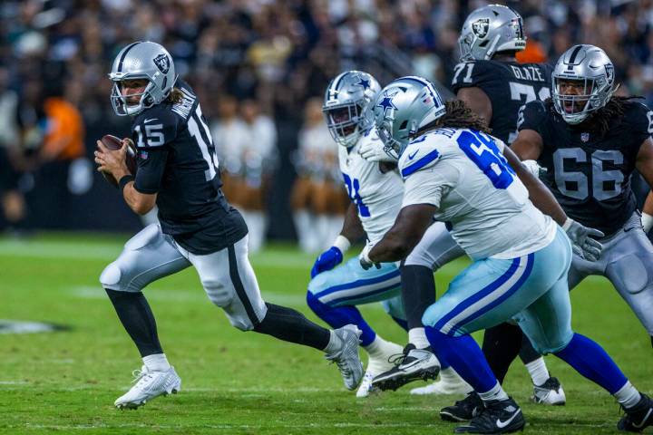 Raiders quarterback Gardner Minshew (15) looks for yardage after flushed from the pocked by Dal ...