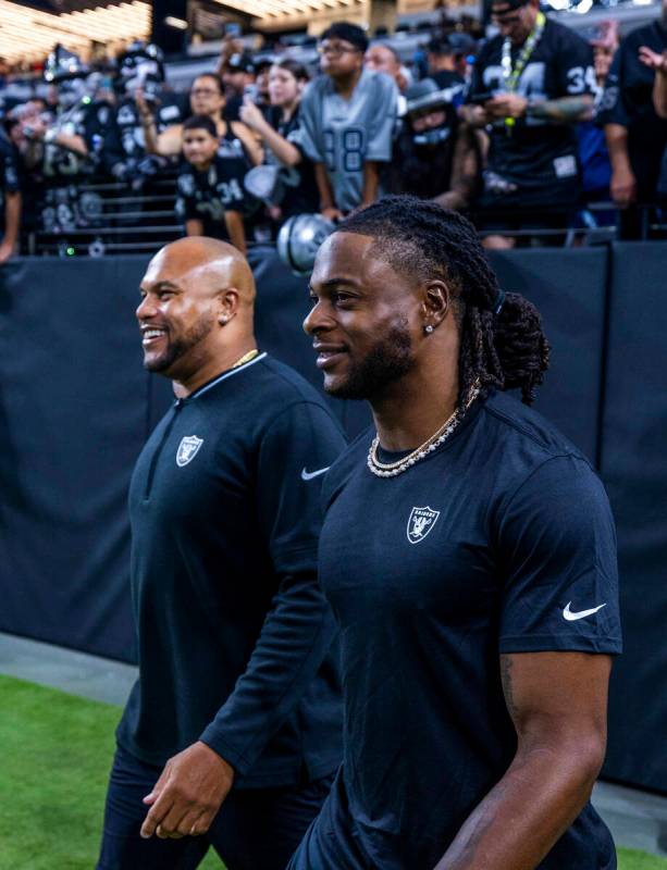 Raiders head coach Antonio Pierce and wide receiver Davante Adams (17) take the field for the f ...