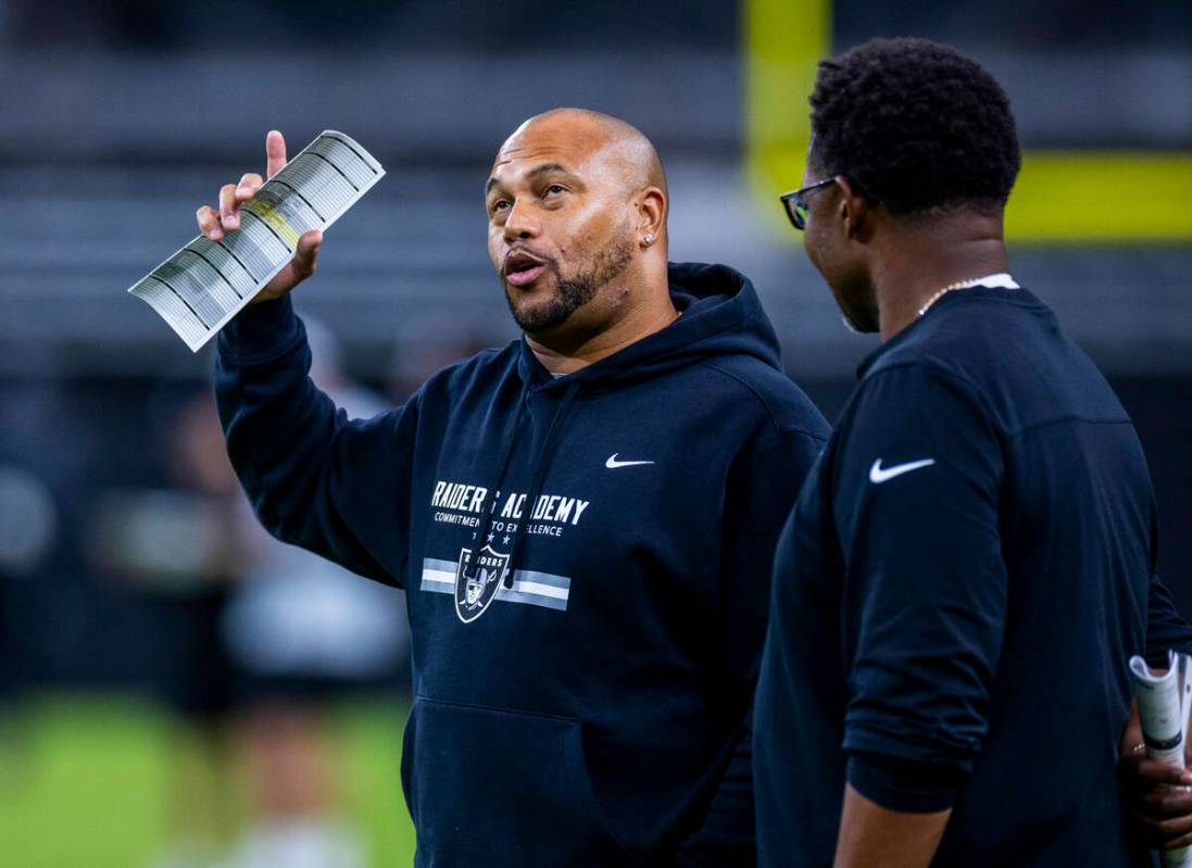 Raiders head coach Antonio Pierce talks with another coach during an open practice at Allegiant ...