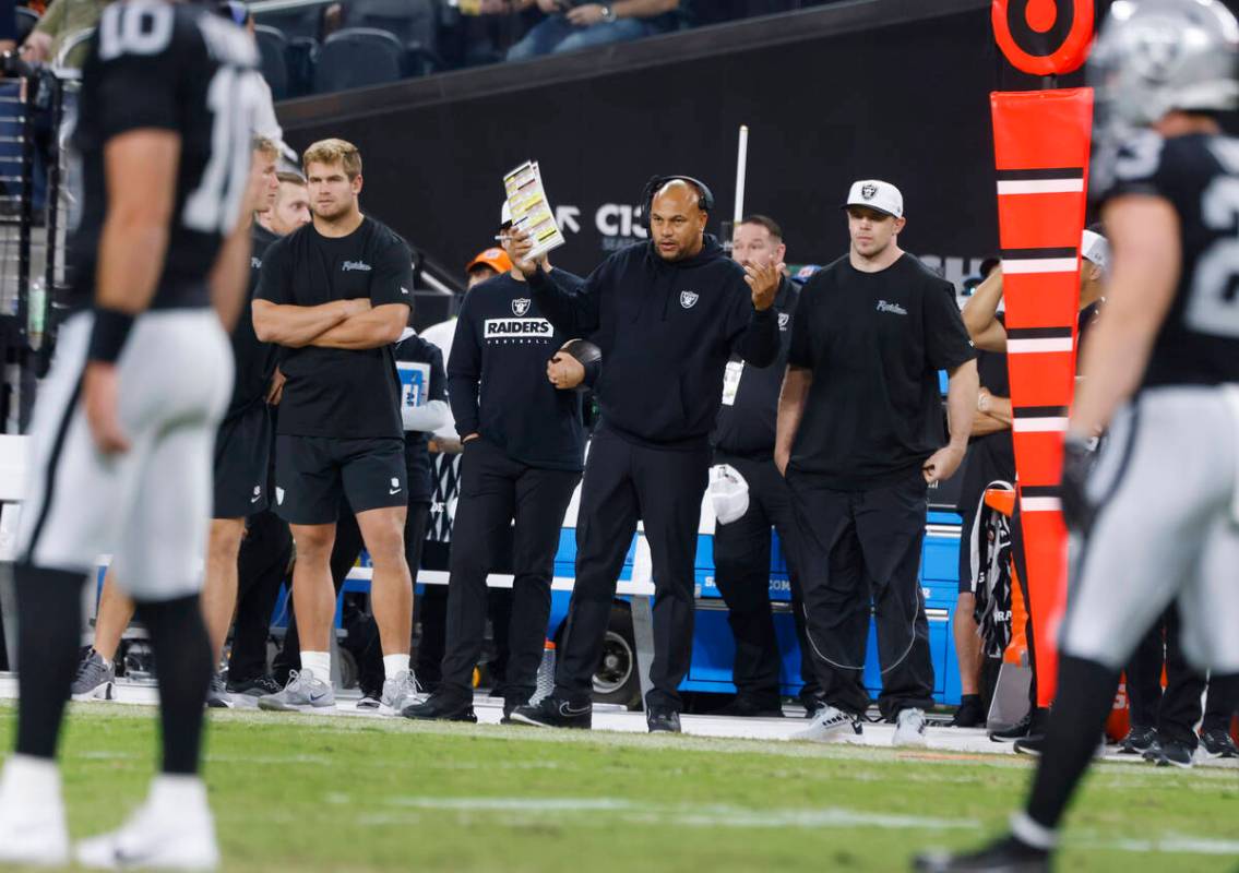 Raiders head coach Antonio Pierce center, reacts from the sideline as he watches his players wa ...