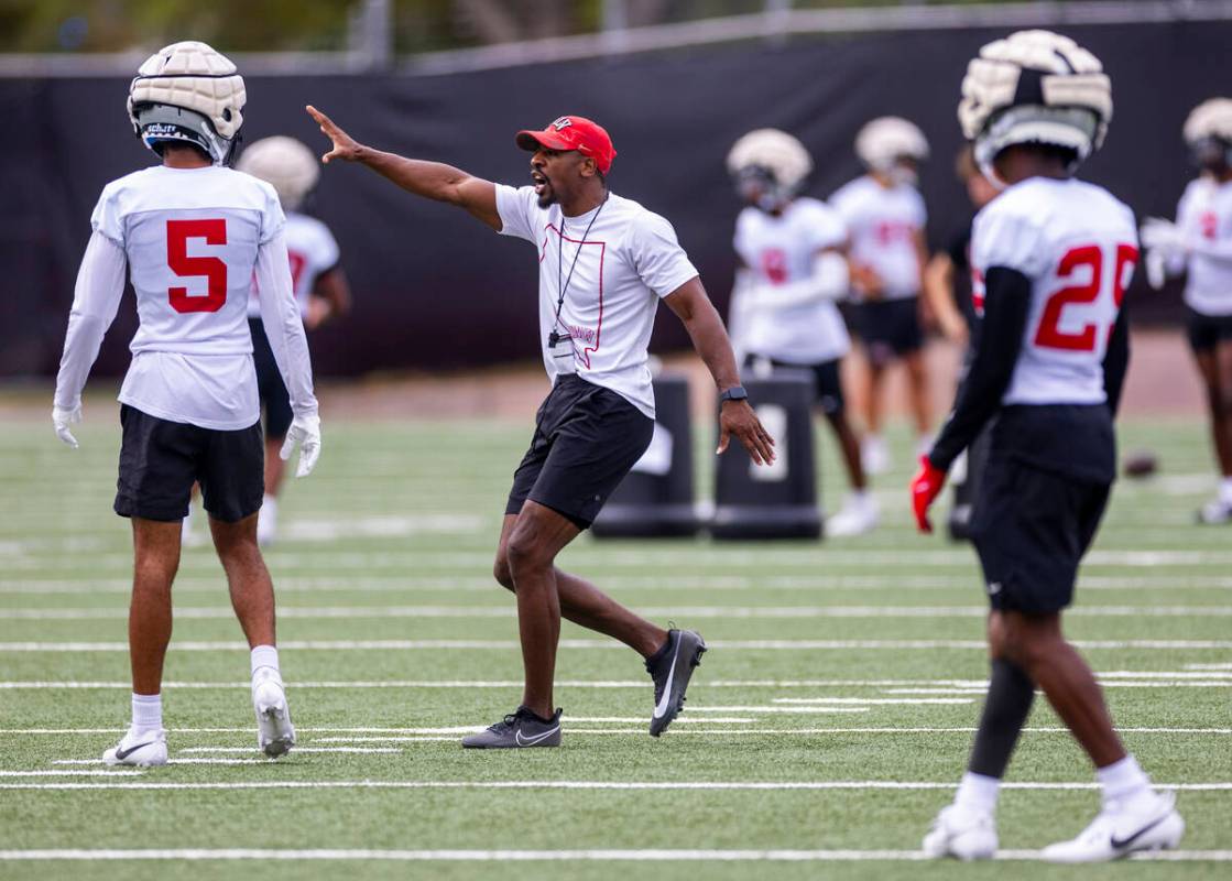 UNLV cornerbacks coach Akeem Davis works with defensive back Cameron Oliver (5) during the firs ...