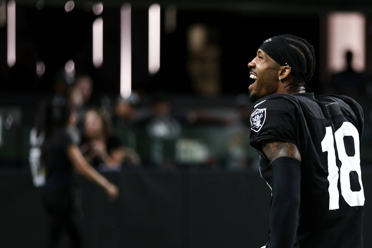 Raiders cornerback Jack Jones (18) pumps up the crowd during an NFL football practice at Allegi ...