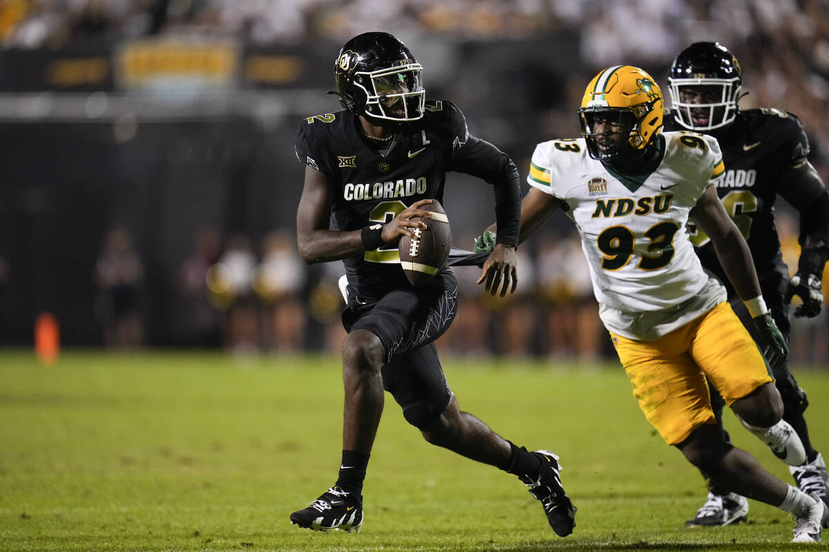 Colorado quarterback Shedeur Sanders runs against North Dakota State during an NCAA college foo ...