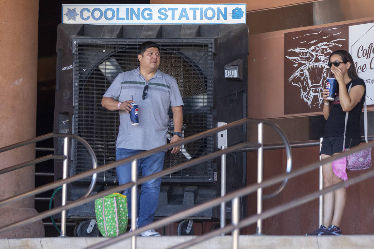 Tourists stand in the shade near a large cooling station fan at the Hoover Dam Friday, July 5, ...