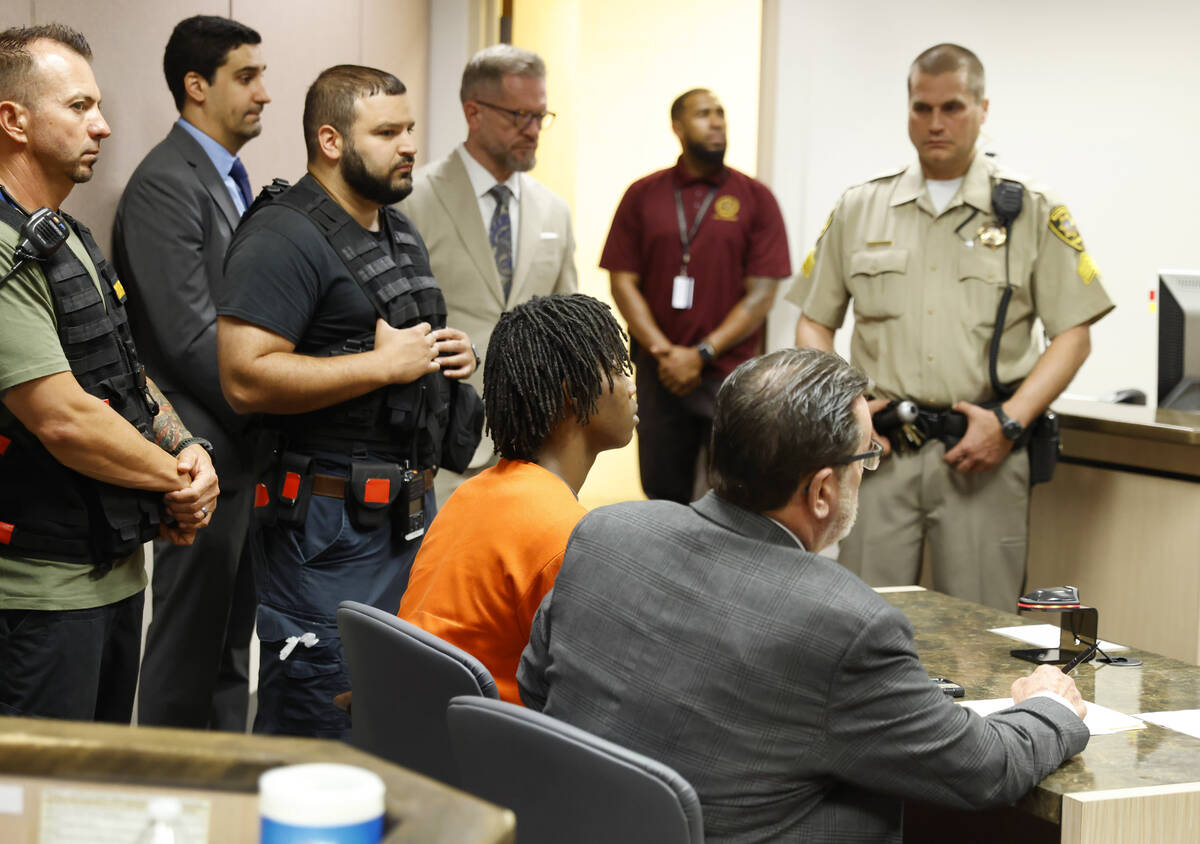 Dontral Beaver, center, appears in Clark County Family Court with his attorney J.D. Evans durin ...