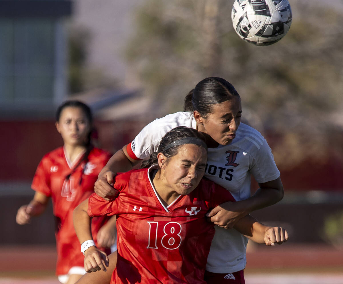 Arbor View freshman Mai Ly Hayes (18) and Liberty defender Nai'a Pomaikai (16) compete for the ...