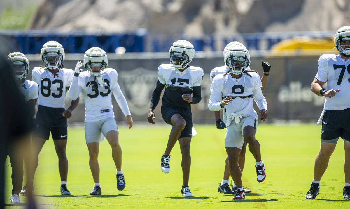 Raiders wide receiver Davante Adams (17) and teammates stretch during practice at the Intermoun ...