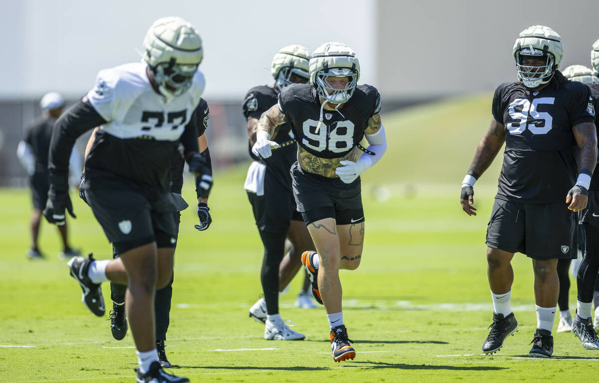 Raiders defensive end Max Crosby (98) runs a drill with teammates during practice at the Interm ...