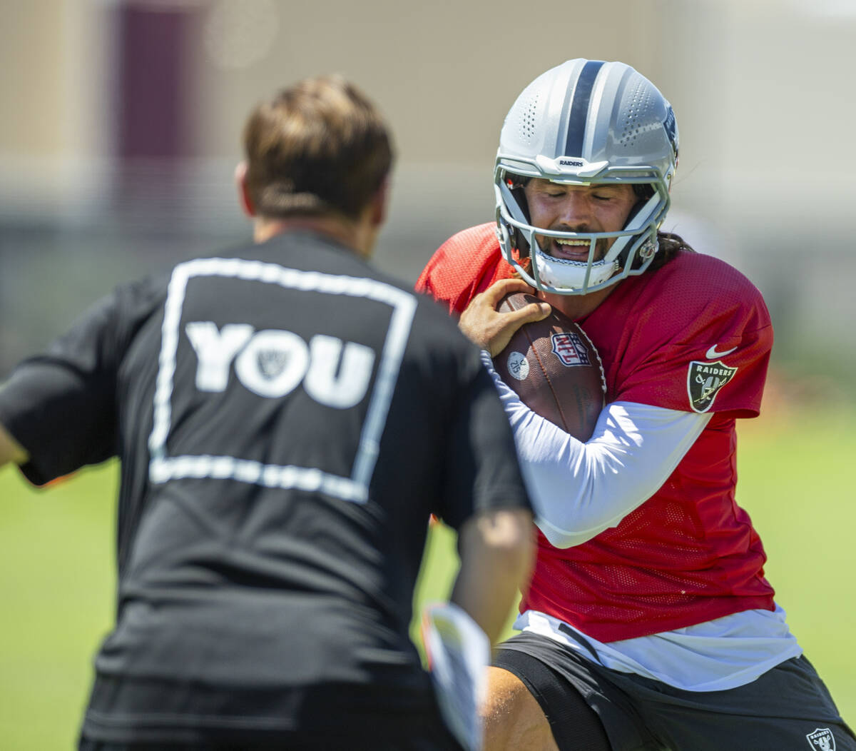 Raiders quarterback Gardner Minshew (15) makes a cut with the ball on a run during a drill in p ...