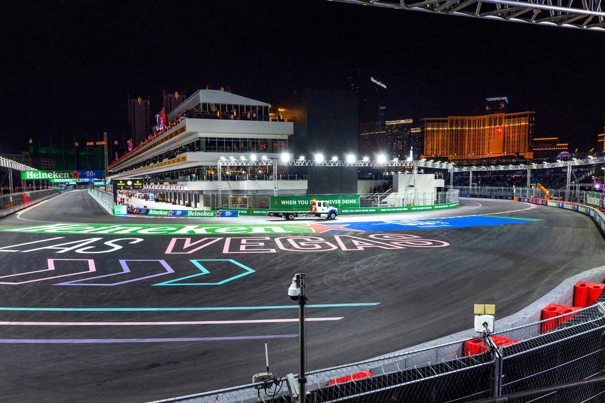 A tow truck heads out from the pit building to collect the car of Carlos Sainz with Ferrari aft ...