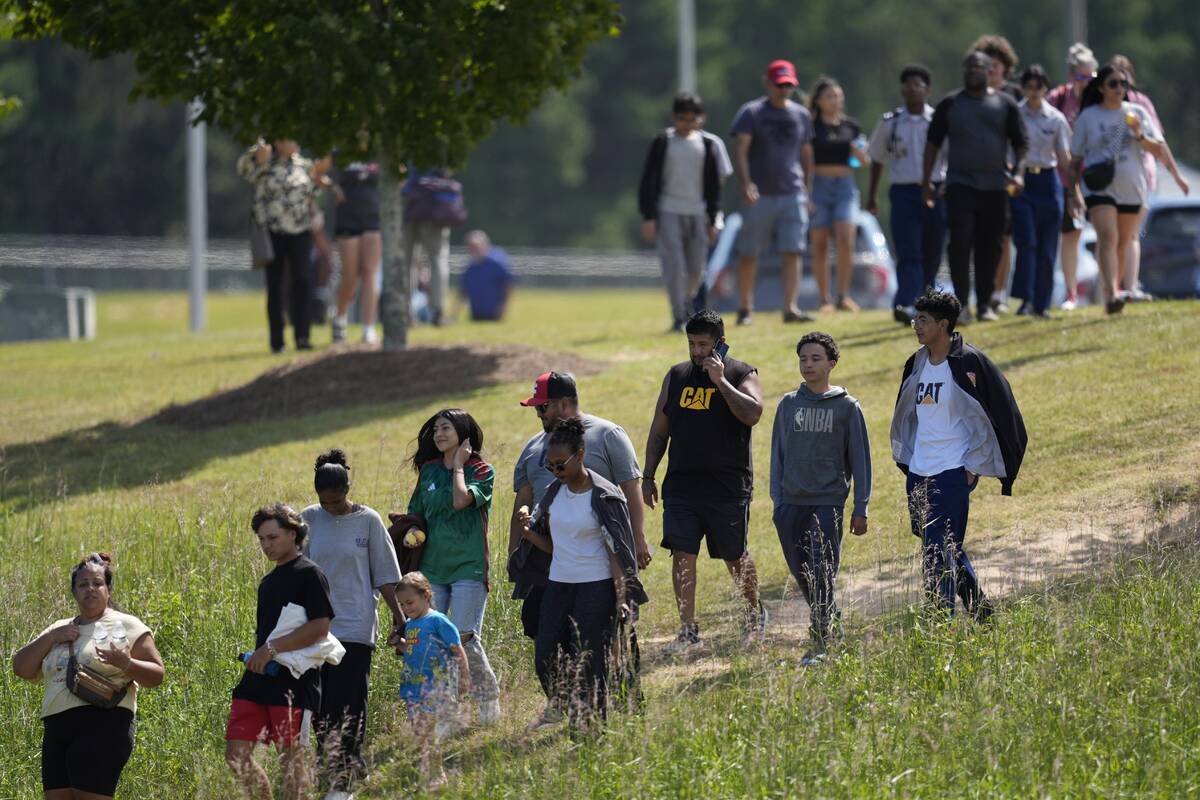 Students and parents walk off campus at Apalachee High School, Wednesday, Sept. 4, 2024, in Win ...