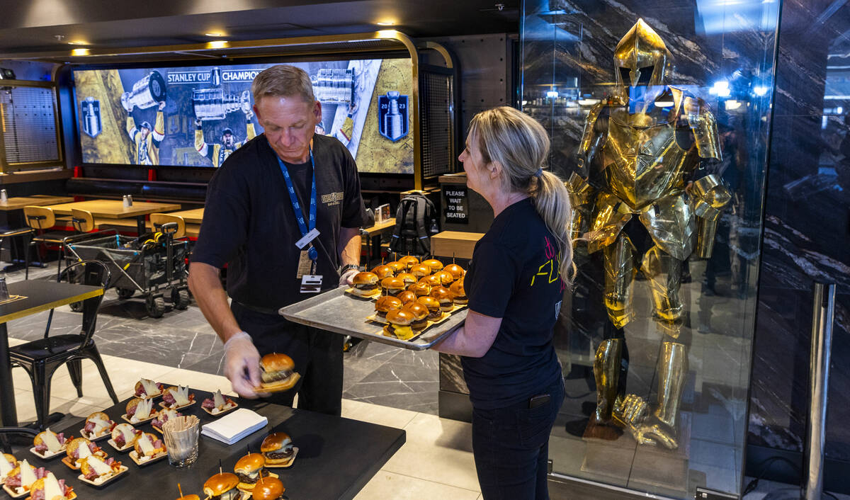 Staff put out some of the food to be sampled by guests during the grand opening celebration for ...