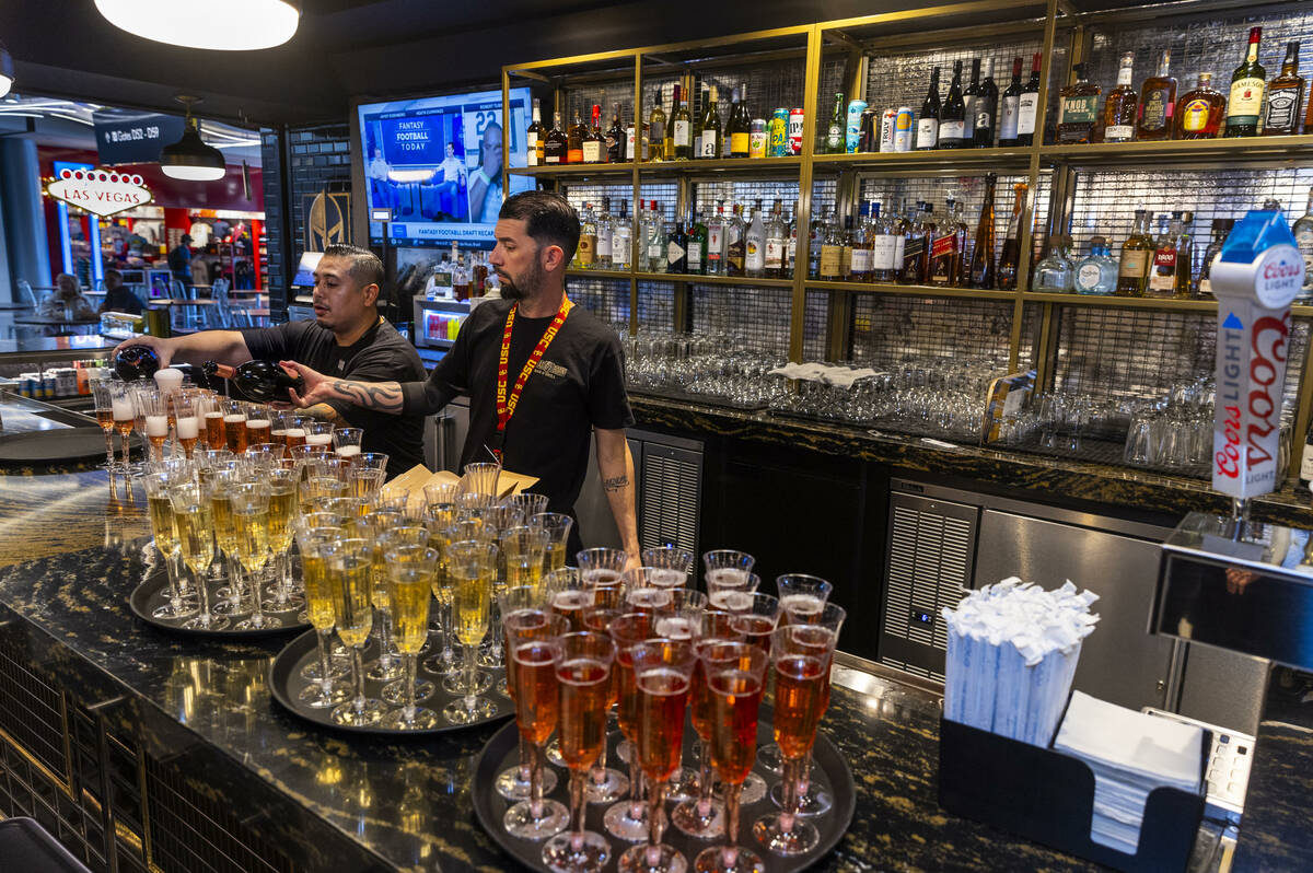 Bartenders put dinks for guests to sample during the grand opening celebration for the Vegas Bo ...