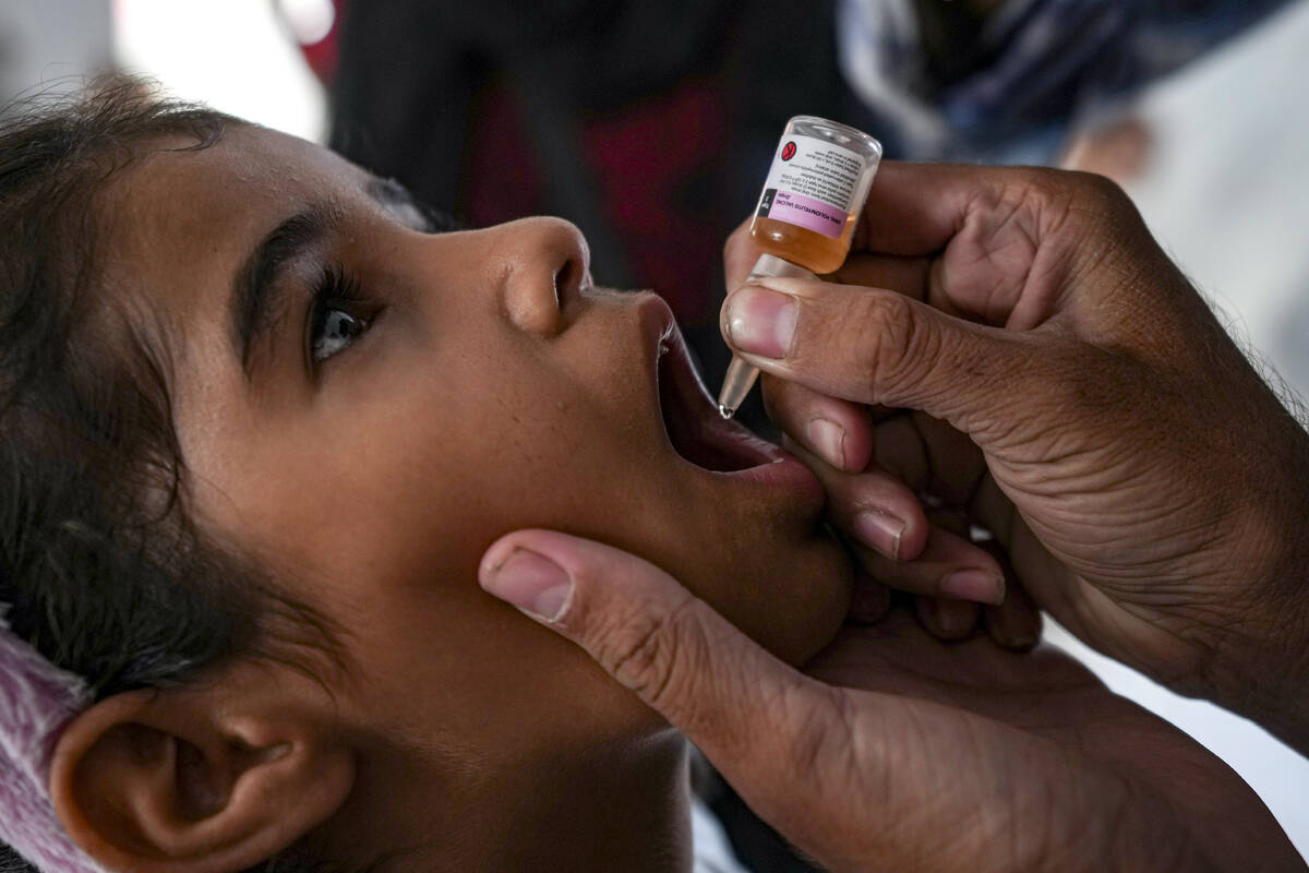 A health worker administers a polio vaccine to a child at a hospital in Deir al-Balah, central ...