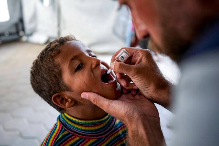 A health worker administers a polio vaccine to a child at a hospital in Deir al-Balah, central ...