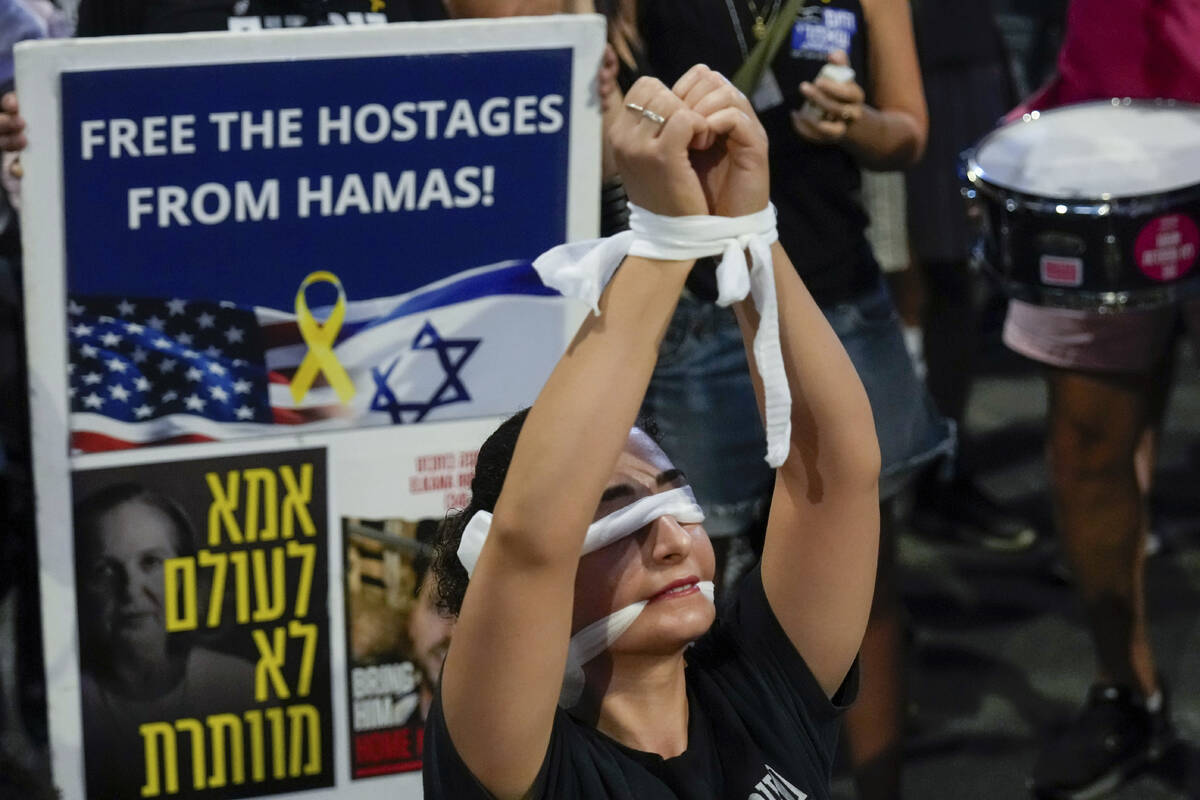 A woman wears a blindfold during a protest calling for a cease-fire deal and the immediate rele ...