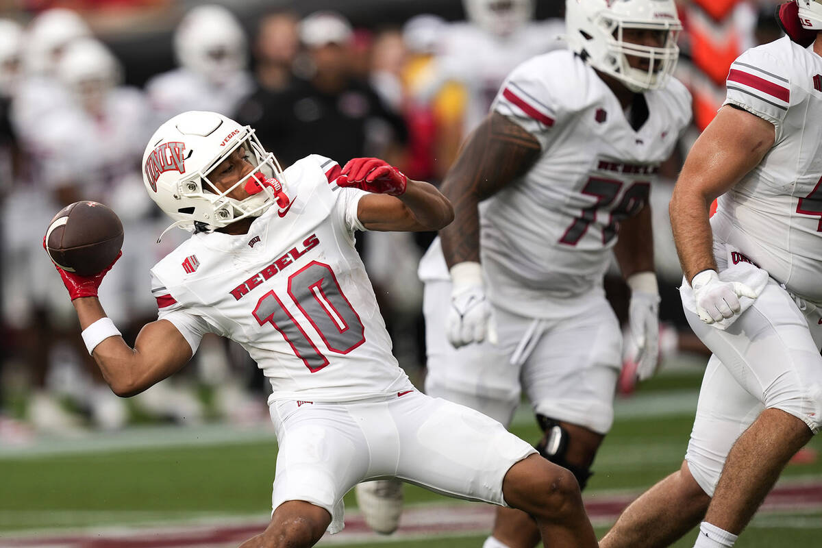 UNLV wide receiver DeAngelo Irvin Jr. (10) reaches back to throw an option pass that went for a ...