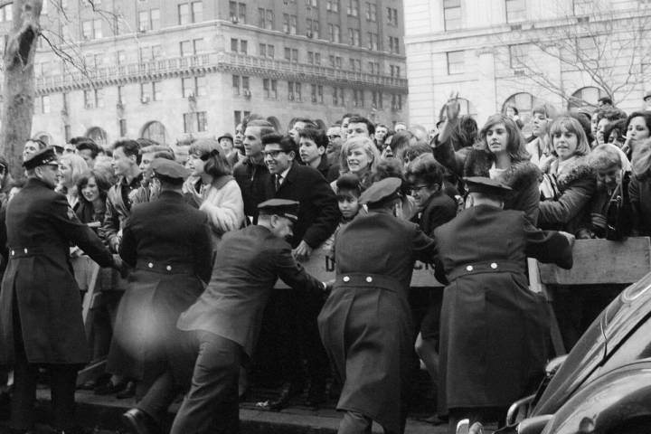 Young fans cheer the arrival of the Beatles at New York City's Plaza Hotel on Feb. 7, 1964. Amo ...