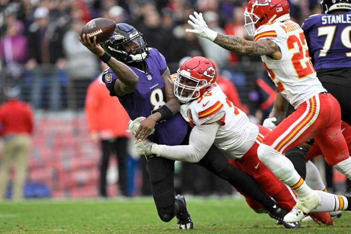 Baltimore Ravens quarterback Lamar Jackson (8) is pressured by Kansas City Chiefs defensive tac ...