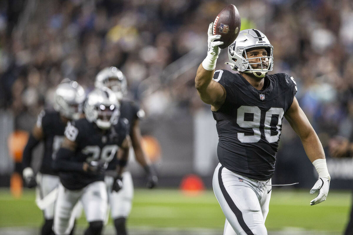 Raiders defensive tackle Jerry Tillery (90) holds up the football after forcing a fumble during ...