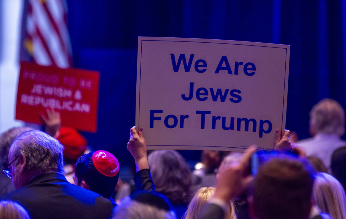 Signs are held up by attendees during the Republican Jewish Coalition’s annual leadershi ...