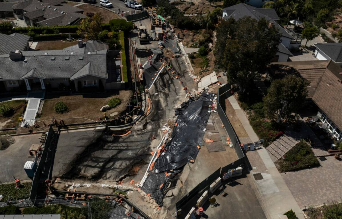 Collapsed roads are covered with tarps in a neighborhood damaged by ongoing landslides in Ranch ...