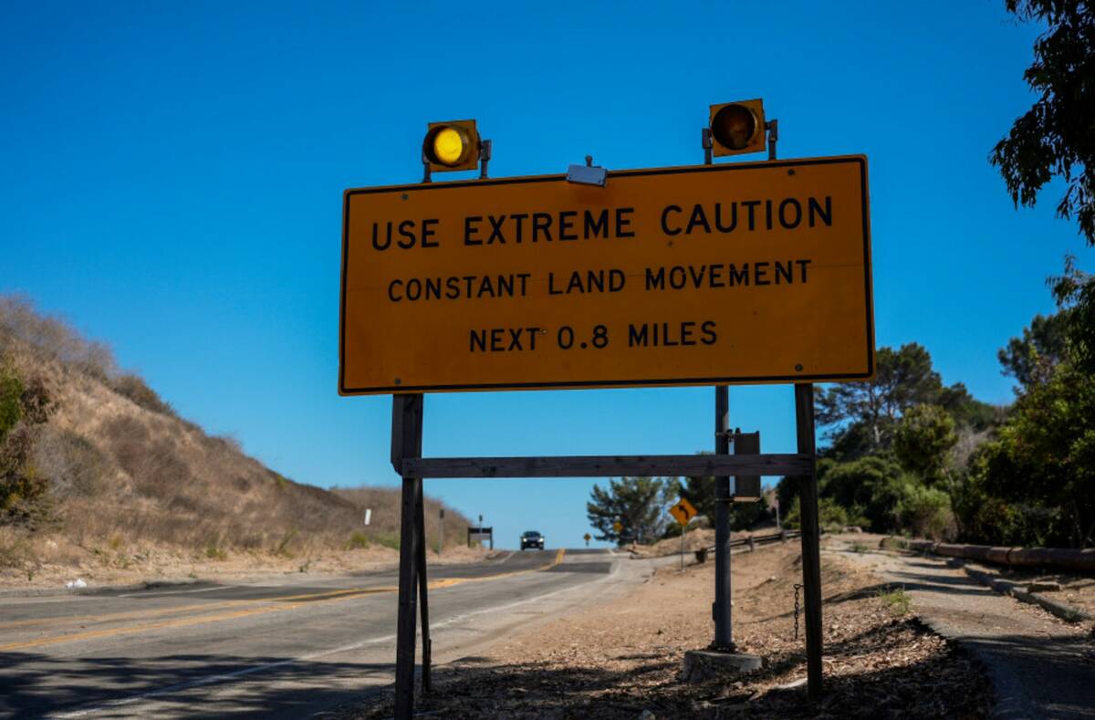 A warning sign stands along a section of road affected by ongoing landslides in Rancho Palos Ve ...