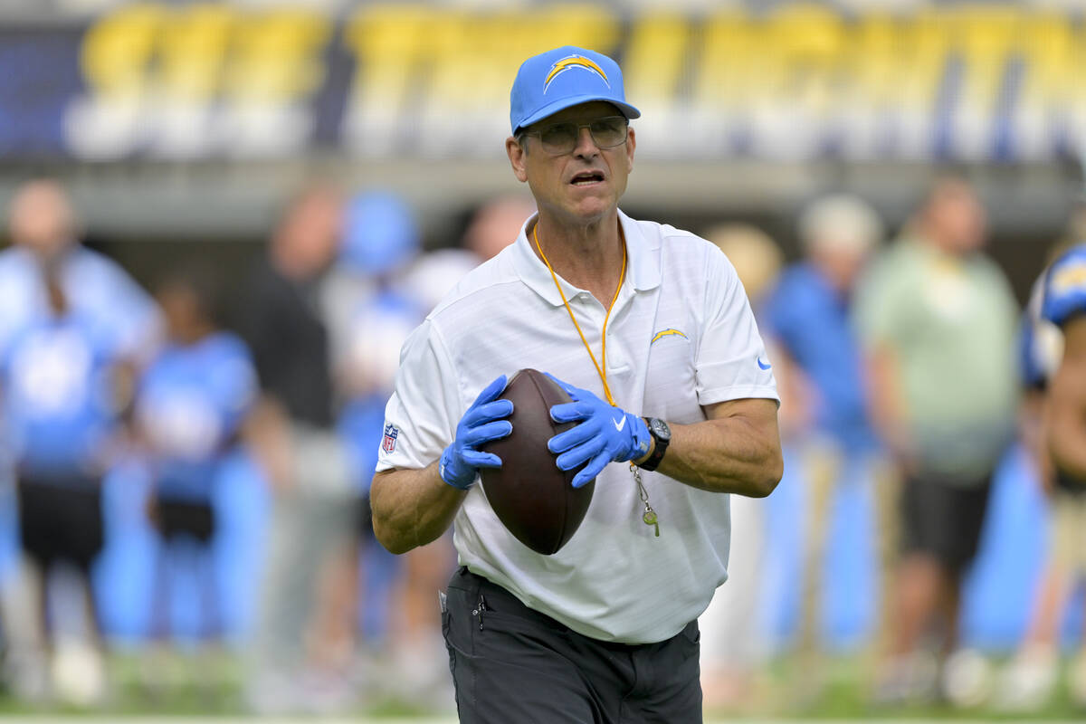 Los Angeles Chargers head coach Jim Harbaugh prepares to throw a pass before a preseason NFL fo ...