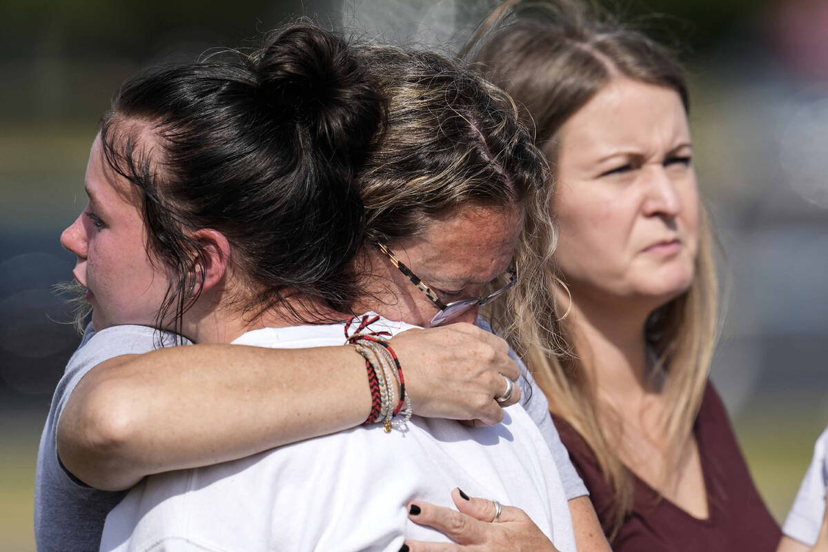 People embrace at a makeshift memorial after a shooting Wednesday at Apalachee High School, Thu ...