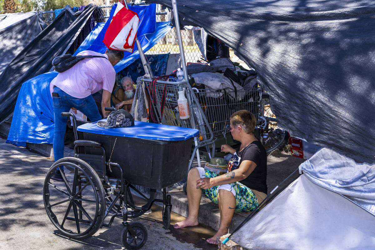 Vegas Stronger's Street Team member Rene Hernandez talks with a homeless man in his shelter al ...