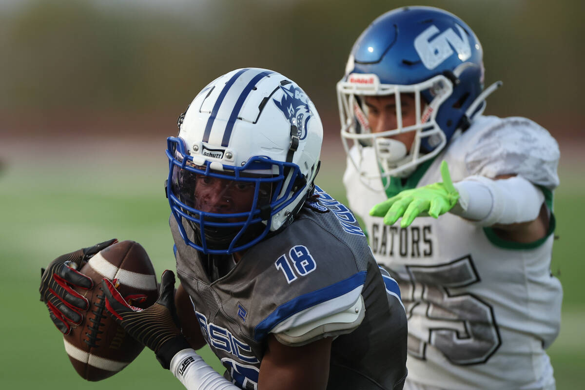 Basic’s Demari McCullough (18) scores a touchdown past Green Valley’s Arjay Tiqui ...