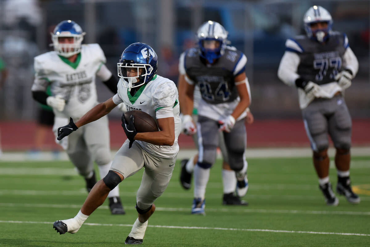 Green Valley wide receiver Aiden Adams (11) carries the ball up the field during a high school ...