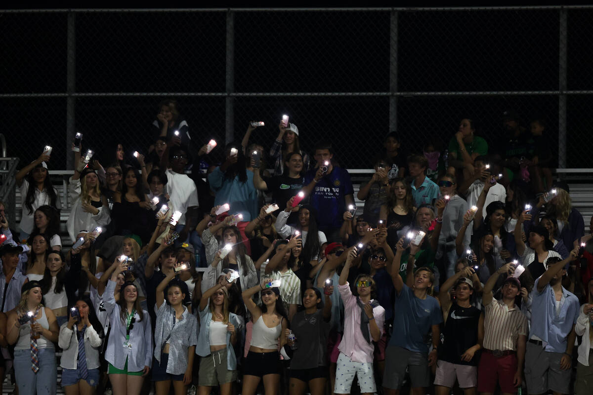 Green Valley fans wave their cell phone flashlights during the second half of a high school foo ...