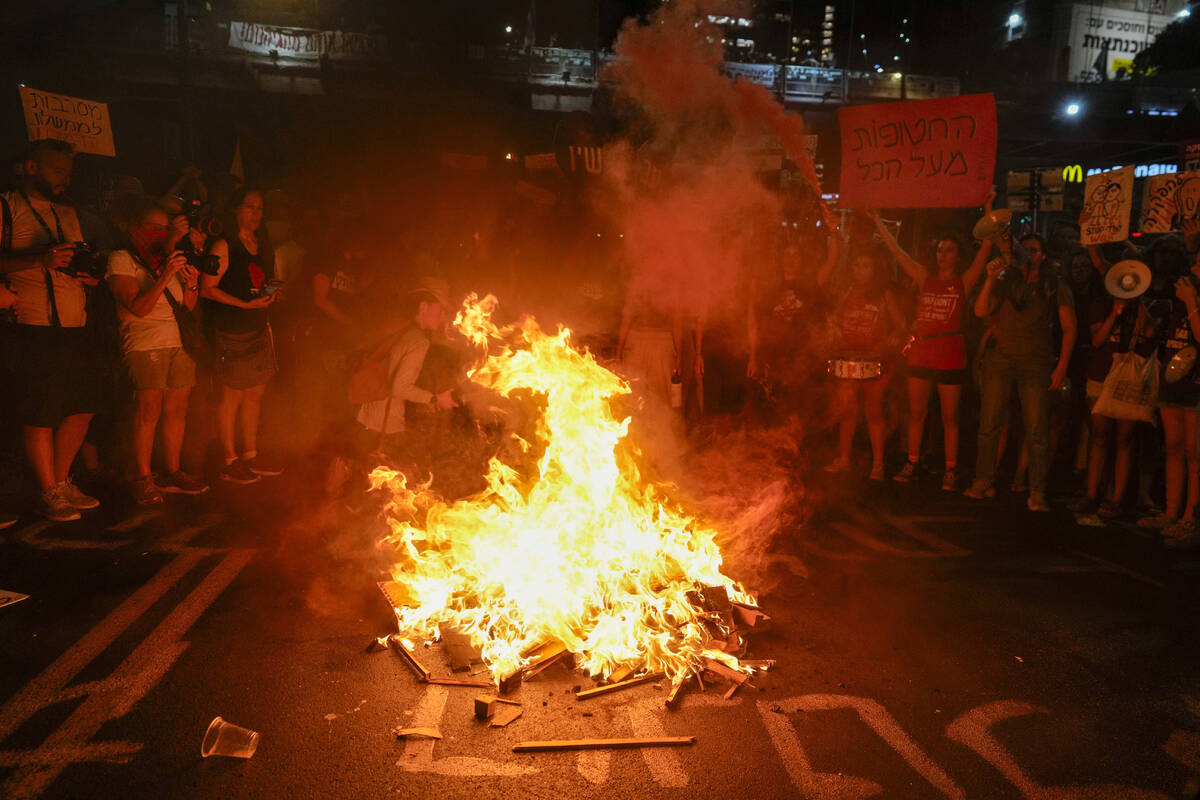 Demonstrators light a bonfire during a protest demanding a cease-fire deal and the immediate re ...