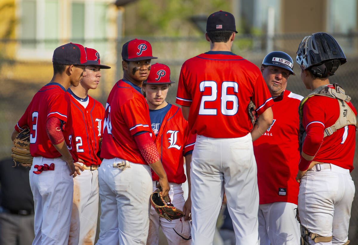 Liberty players come together with coach Rich Ebarb during a timeout against Spring Valley duri ...