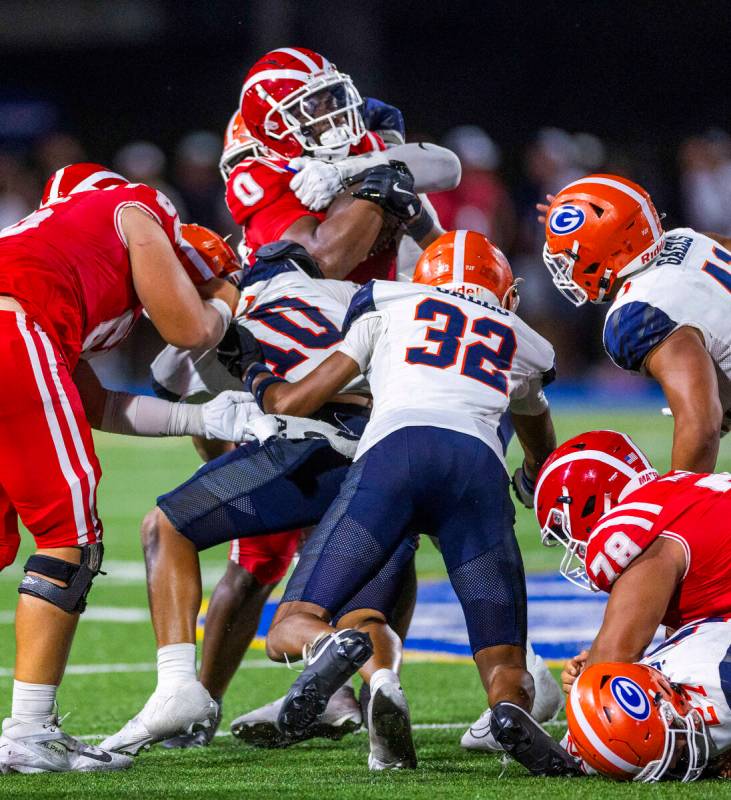 Mater Dei running back Jordon Davison (0) is swarmed by Bishop Gorman linebacker Tamatoa Gaoteo ...