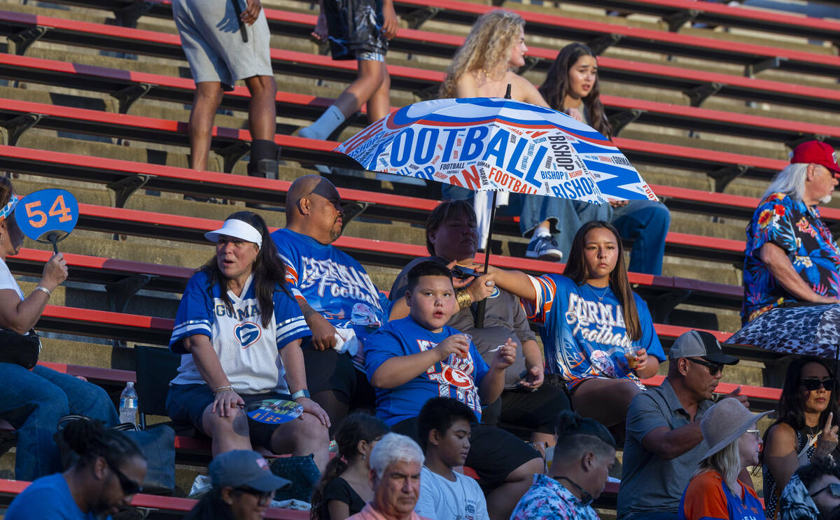 Bishop Gorman fans stay cool under an umbrella as they face Mater Dei during the first half of ...