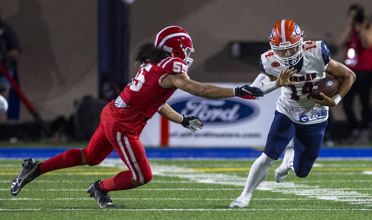 Bishop Gorman quarterback Maika Eugenio (14) looks to evade a tackle attempt by Mater Dei lineb ...