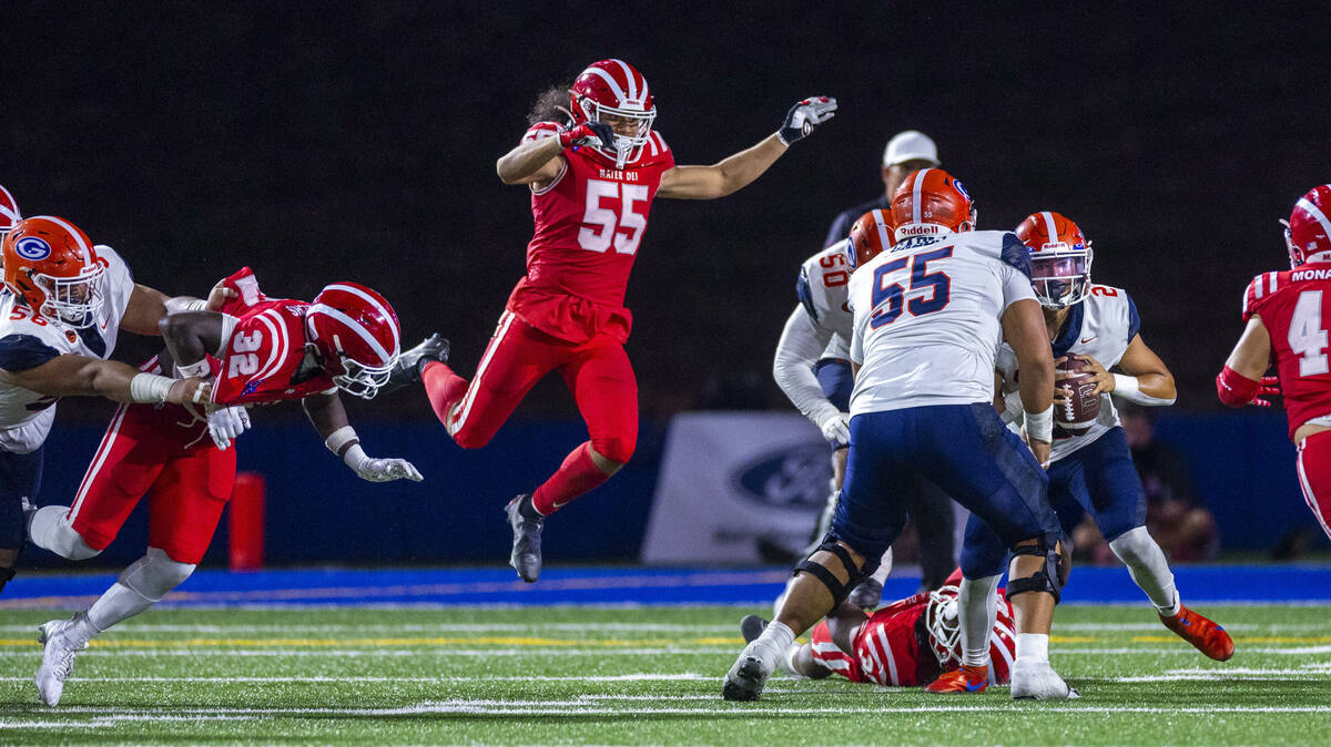 Bishop Gorman quarterback Melvin Spicer IV (2) scrambles to avoid a sack as Mater Dei linebacke ...